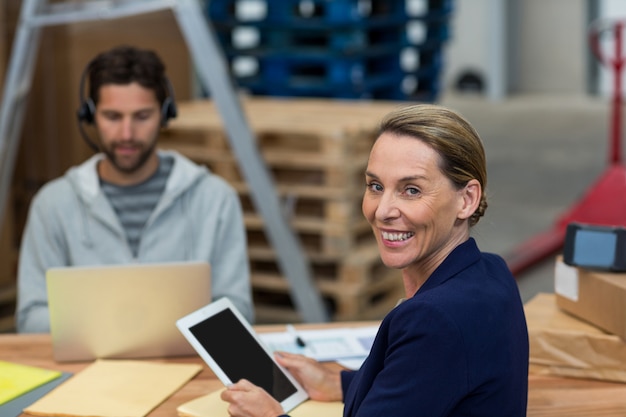 Lavoratore sorridente che esamina macchina fotografica