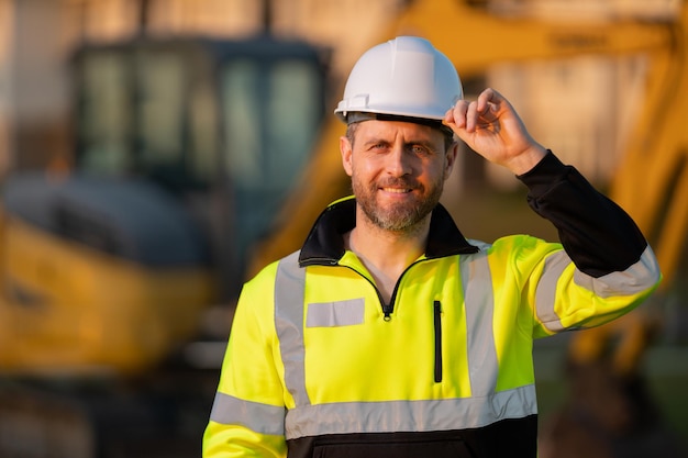 Lavoratore uomo piccolo imprenditore edile operaio con elmetto protettivo casco sul cantiere constru