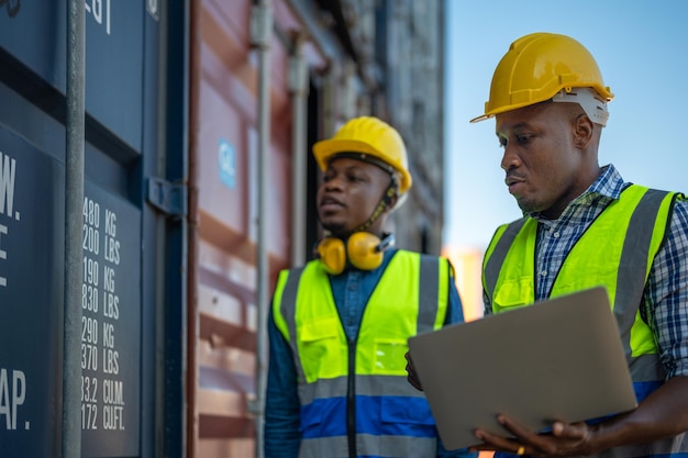 Lavoratori africani Ingegnere Tecnico con laptop per ispezionare l'area dei contenitori in loco