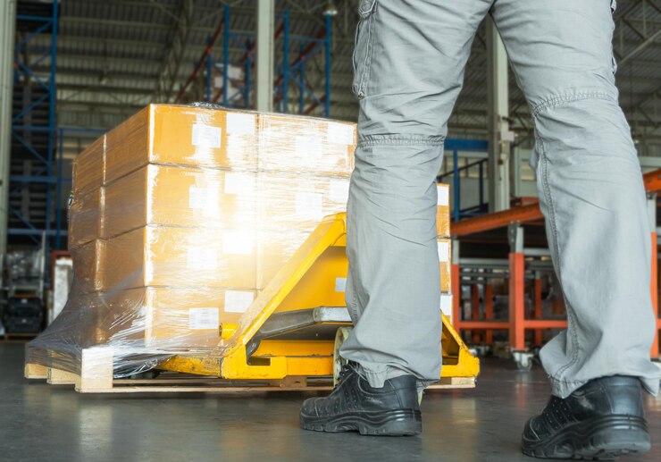 Lavoratori che scaricano scatole di imballaggio nella catena di approvvigionamento del magazzino Scatole per spedizioni uomo di consegna