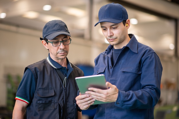 Lavoratori che utilizzano un tablet in una fabbrica moderna