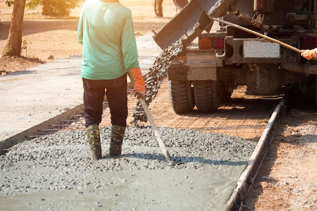 Lavoratori che versano calcestruzzo con un camion betoniera