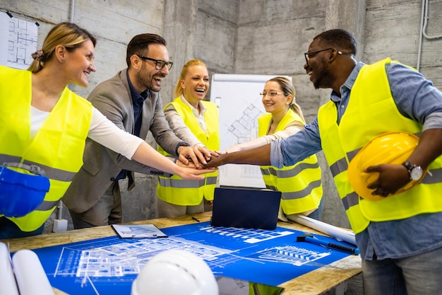 Lavoratori del cantiere che si tengono per mano insieme per un lavoro di successo