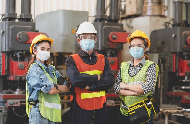 Lavoratori del gruppo che indossano maschera protettiva e giubbotto di sicurezza sul lavoro