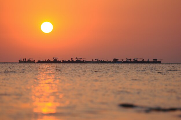 Lavoratori delle barche del mare di alba di tramonto