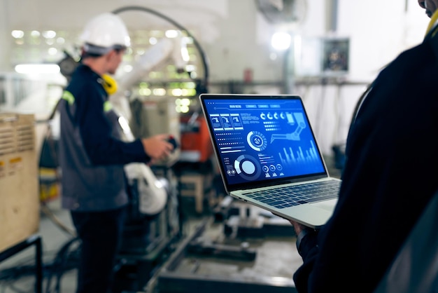 Lavoratori di fabbrica che lavorano con un abile braccio robotico in un'officina