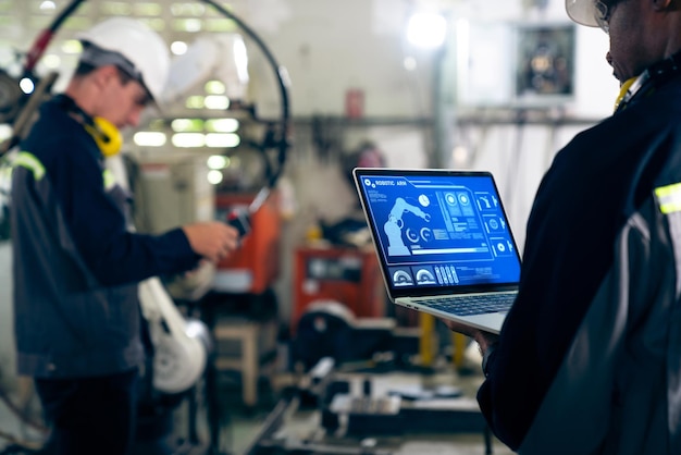 Lavoratori di fabbrica che lavorano con un abile braccio robotico in un'officina