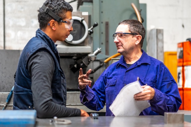 Lavoratori di fabbriche industriali metalliche del settore del controllo numerico che parlano