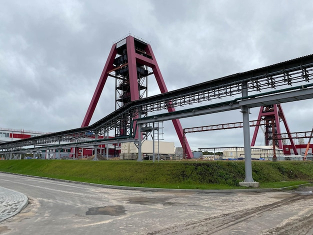 Lavoratori di impianti dell'industria chimica in abiti da lavoro in una raffineria con tubi e macchinari