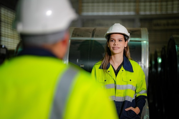 Lavoratori di ingegneria professionisti camminano e controllano il magazzino della fabbrica