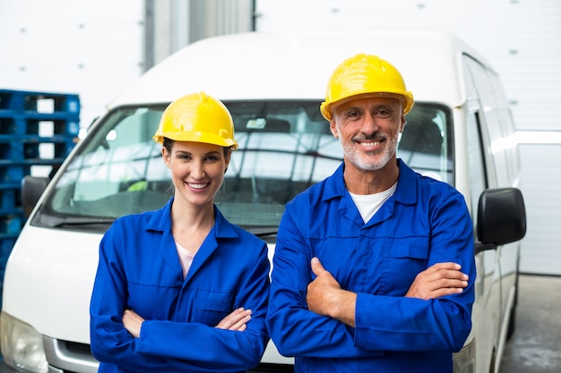 Lavoratori sorridenti che attraversano le armi alla macchina fotografica