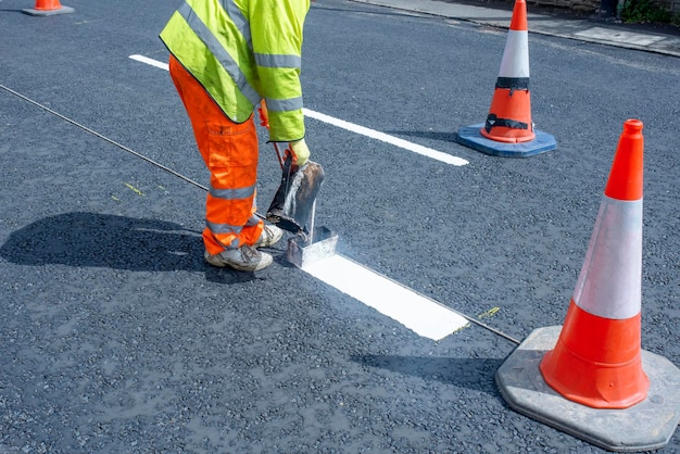 Lavoratori stradali che applicano vernice resistente al traffico hot melt per linee di segnaletica stradale bianche gialle e rosse