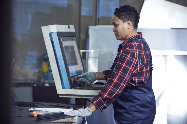 Lavoratrice che utilizza le macchine nell'officina