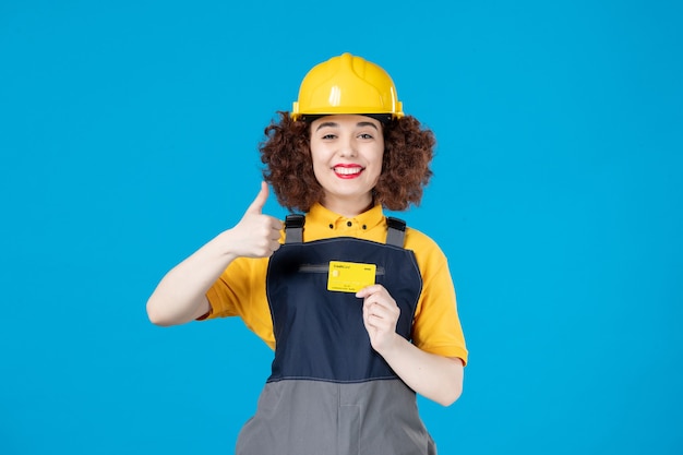 Lavoratrice in uniforme con carta di credito su un blu