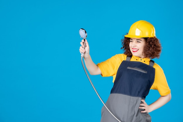Lavoratrice in uniforme gialla con doccia sul blu