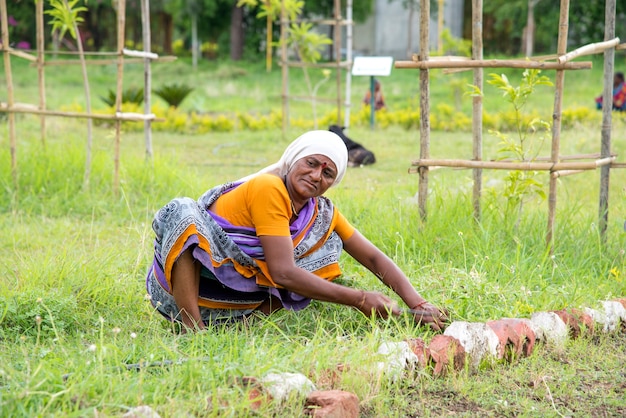 Lavoratrici che tagliano erba indesiderata dal campo del giardino