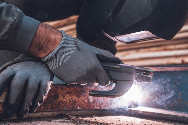 Lavori di saldatura, saldatura uomo in officina. Carpenteria metallica e scintille. Concetto di costruzione e industriale.