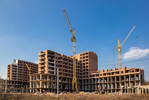 Lavori in corso su un nuovo condominio Alto edificio in costruzione con gru Cantiere di nuova costruzione