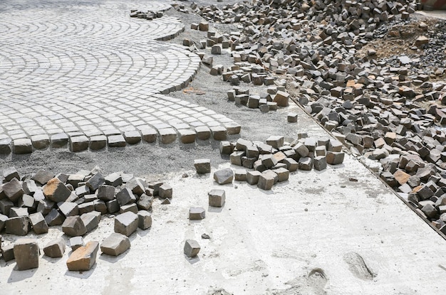 Lavori stradali nel centro storico. Pietre e piastrelle per pavimentazione a terra. Ricostruzione per le strade. Riparazione del marciapiede. Calcestruzzo.