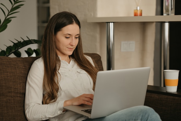 Lavoro a distanza. Una donna caucasica che lavora a distanza sul suo computer portatile