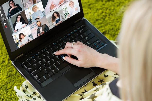 Lavoro a distanza Videochiamata di gruppo Webcast aziendale Libero professionista femminile che utilizza il laptop che collabora online con i colleghi sullo schermo in un ufficio virtuale