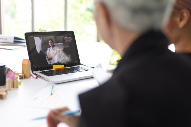 Lavoro da casa, distanza sociale, videoconferenza e concetto di riunione online. Riunione di videochiamata di una donna d'affari asiatica su leptop a casa