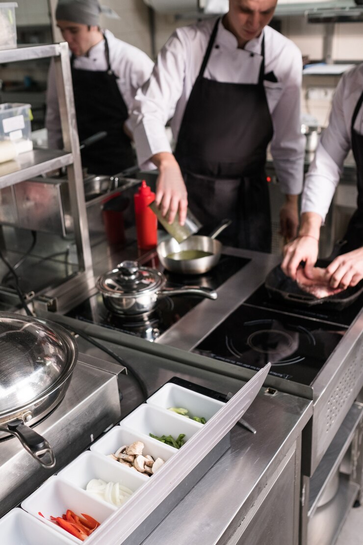 Lavoro di routine per preparare gli ingredienti per deliziosi pasti al ristorante. Cuochi al lavoro in cucina