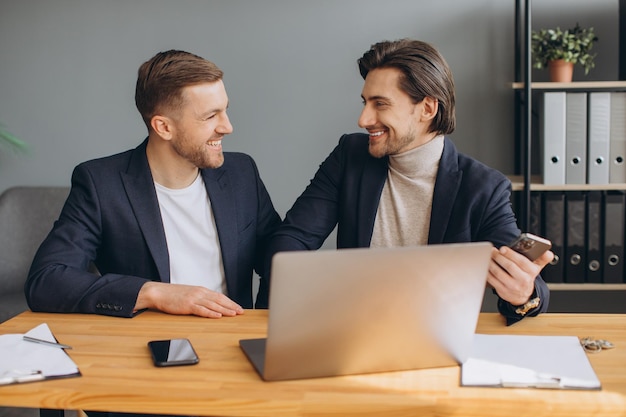 Lavoro di squadra di affari due uomini d'affari corporativi sorridenti che lavorano insieme sul computer portatile