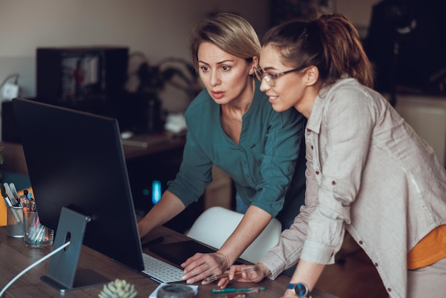 Lavoro di squadra, donne che lavorano insieme al computer, che fanno progetti in ufficio a casa.