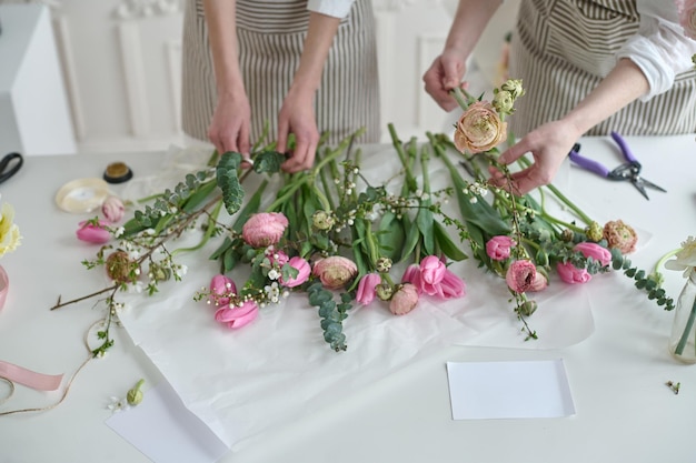 Lavoro di squadra Due giovani bellissimi fioristi creano un bouquet