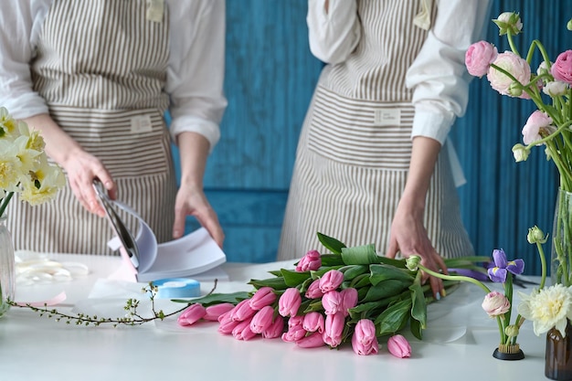 Lavoro di squadra Due giovani bellissimi fioristi creano un bouquet