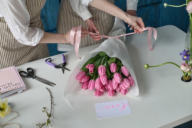 Lavoro di squadra Due giovani bellissimi fioristi creano un bouquet