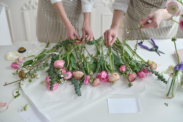 Lavoro di squadra Due giovani bellissimi fioristi creano un bouquet