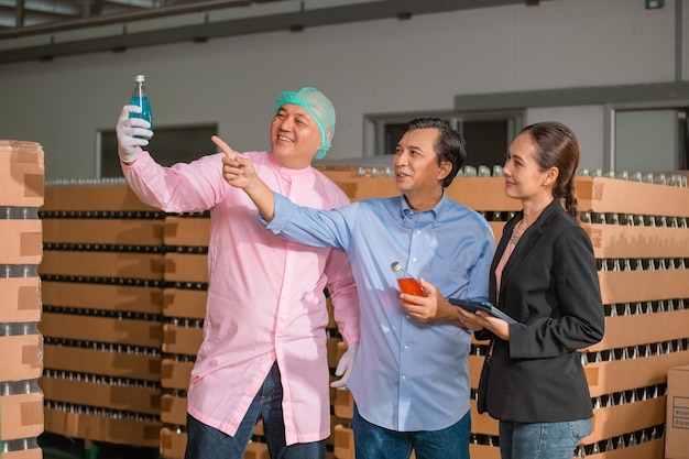 Lavoro di squadra Manager e dipendenti asiatici che lavorano Controllo della qualità degli alimenti in fabbrica e lavoratori nella fabbrica di bevande della linea di produzione Industria alimentare di concetto