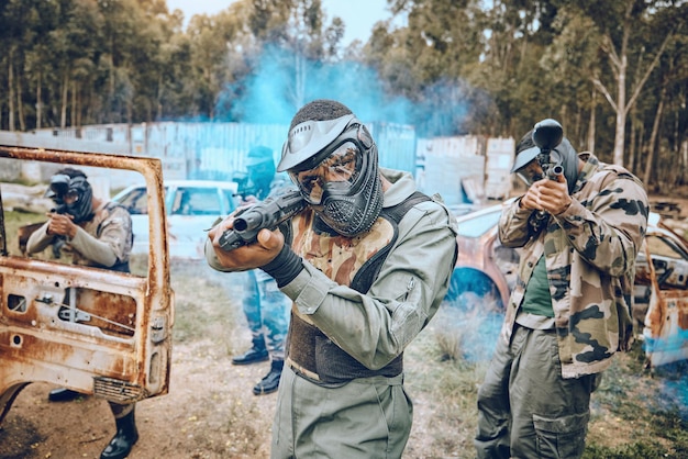 Lavoro di squadra paintball e sport con persone in campo per bersagli eroi e giochi di tiro Fumo di guerra e comunità con giocatori che giocano in mimetica per l'esercito militare e l'addestramento alle competizioni