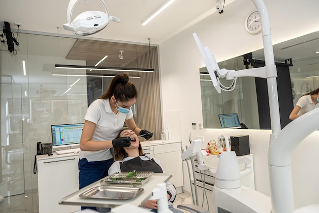 Lavoro di una dentista donna nella propria odontoiatria con una paziente ragazza