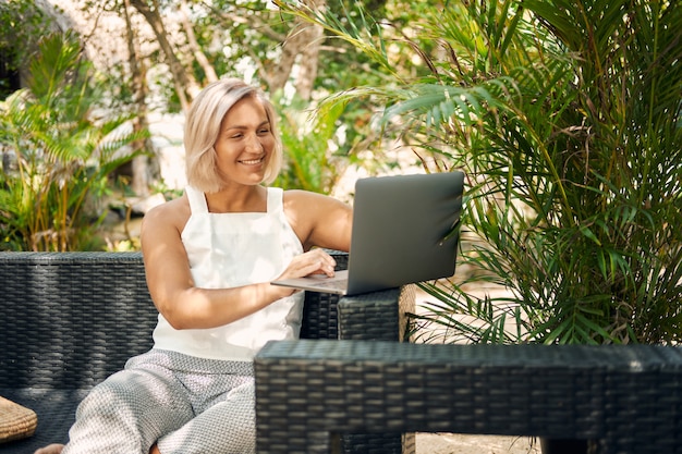 Lavoro libero professionista della donna dal computer portatile sulla vacanza