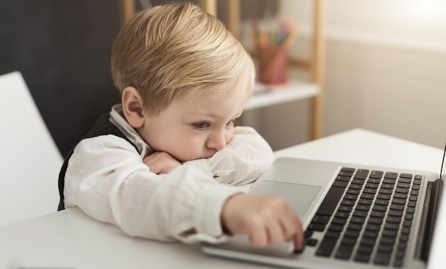 Lavoro noioso. Neonato di affari che spinge la chiave del computer portatile all'ufficio, spazio della copia