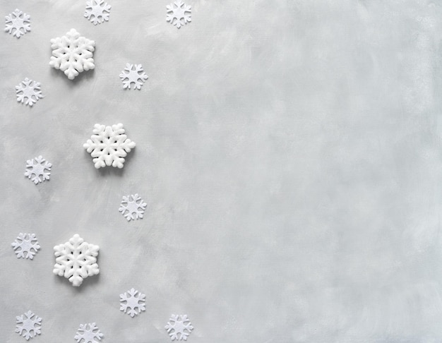 Lay piatto di Capodanno. Cornice fatta di fiocchi di neve su sfondo grigio. Bandiera di Natale.