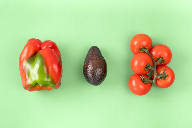 Layout creativo fatto di pepe, avocado e pomodoro. Vista piana laico e dall'alto. Concetto di cibo.