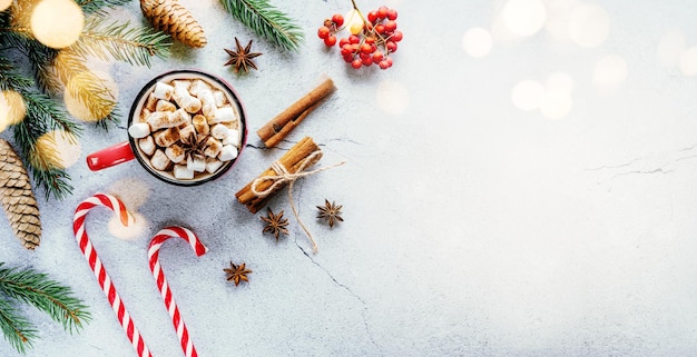 Layout creativo per le vacanze di Natale con rami di abete di cioccolato caldo marshmallow e pigne