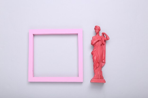 Layout creativo Rosa Statua della dea greca antica con cornice vuota su sfondo grigio Minimalismo Disposizione piatta Vista dall'alto Disposizione piatta