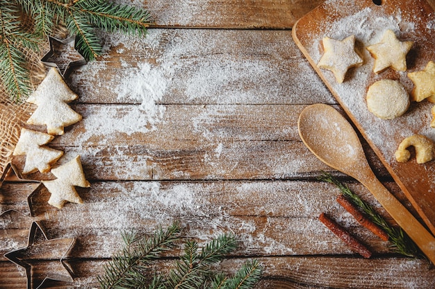 Layout piatto su un tavolo in legno fatto di biscotti di Natale a forma di alberi di Natale