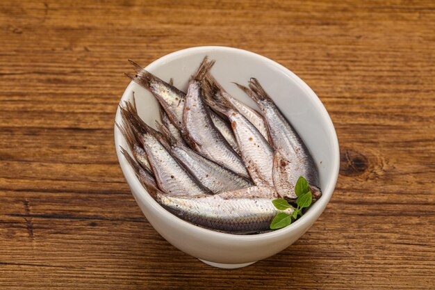 Le acciughe nella ciotola servivano foglie di basilico