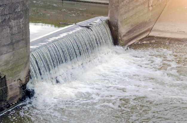 Le acque sporche della città fognaria nel canale fondono la cascata.