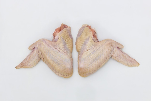 Le ali crude di un pollo sono isolate su uno sfondo bianco