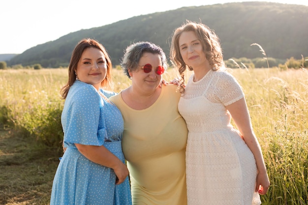 Le amiche felici si stanno abbracciando in natura