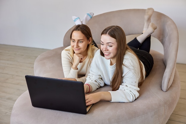 Le amiche guardano film sul laptop in salotto