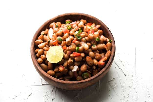 Le arachidi bollite Chaat o Chatpata cantano dana o shengdana o mungfali. servito in una ciotola di ceramica su uno sfondo lunatico