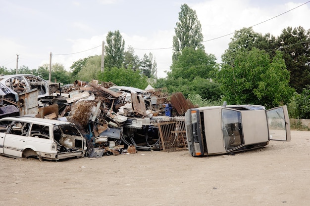 Le auto distrutte sono ammassate in un deposito di rottami pronte per essere riciclate come rottami